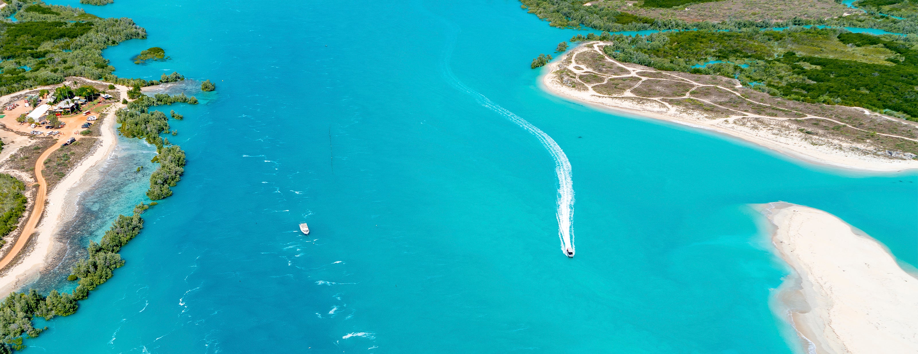 An aerial view of Willie Creek near Broome, showcasing the vibrant turquoise waters, sandy shores, and the Willie Creek Pearl Farm.