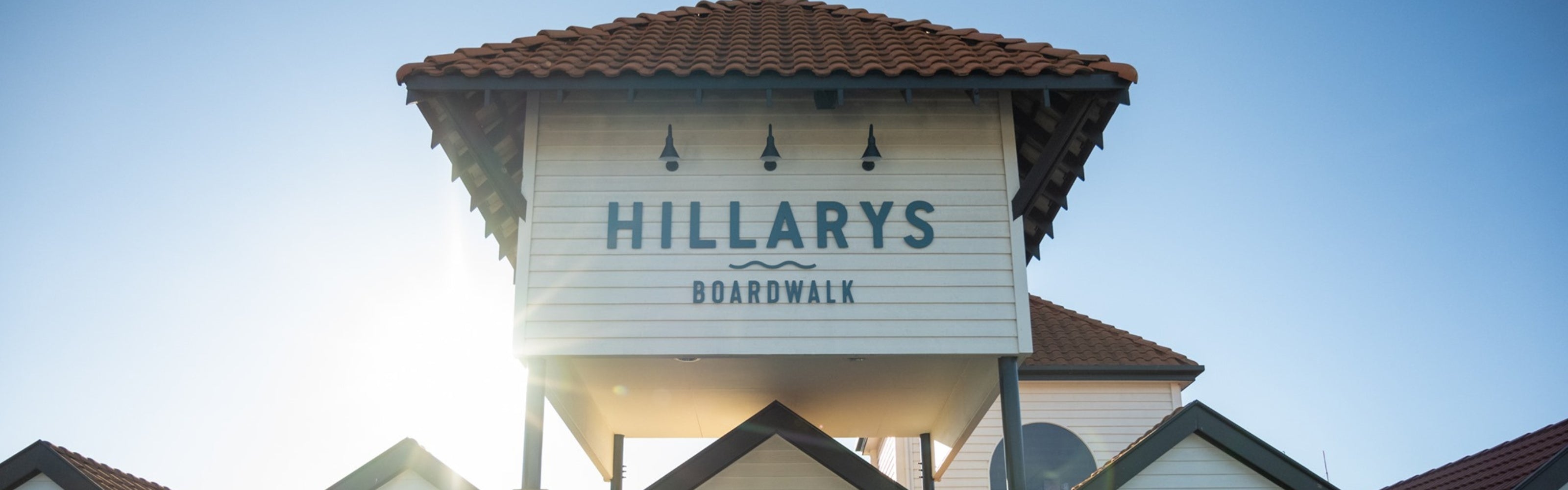 The Hillarys Boardwalk exterior sign above the Willie Creek Pearls jewelry showroom at Hillarys Boat Harbour in Perth, Western Australia, with blue skies in the background.